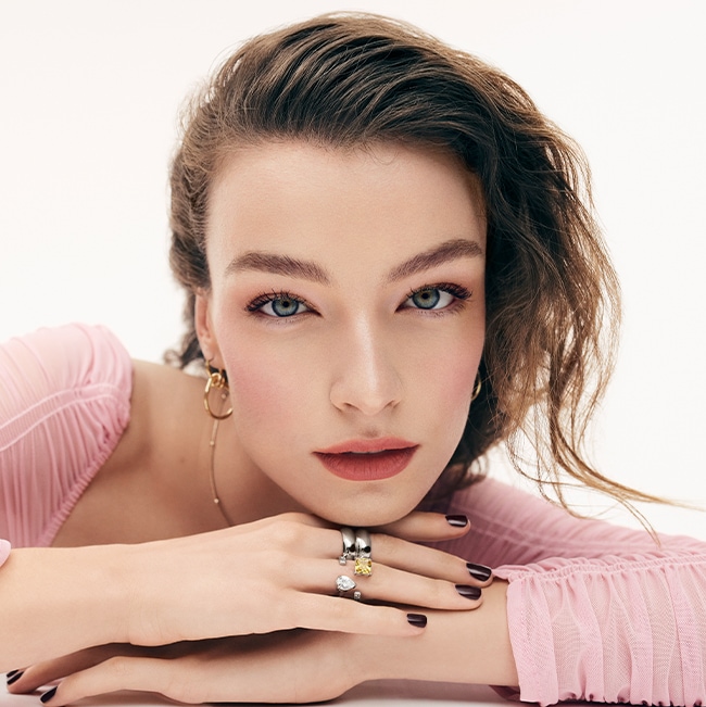 Model applying Skin Long-Wear Weightless Foundation to skin with a foundation brush